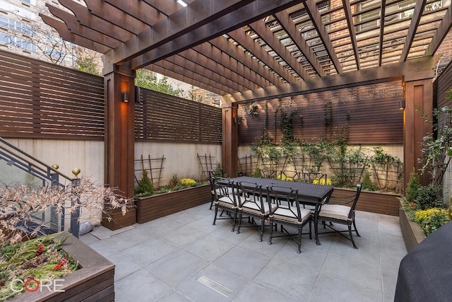 view of patio featuring fence, outdoor dining space, and a pergola