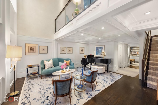 living room featuring recessed lighting, coffered ceiling, wood finished floors, stairs, and beam ceiling