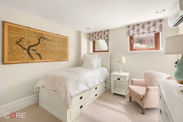 bedroom with an AC wall unit and baseboards