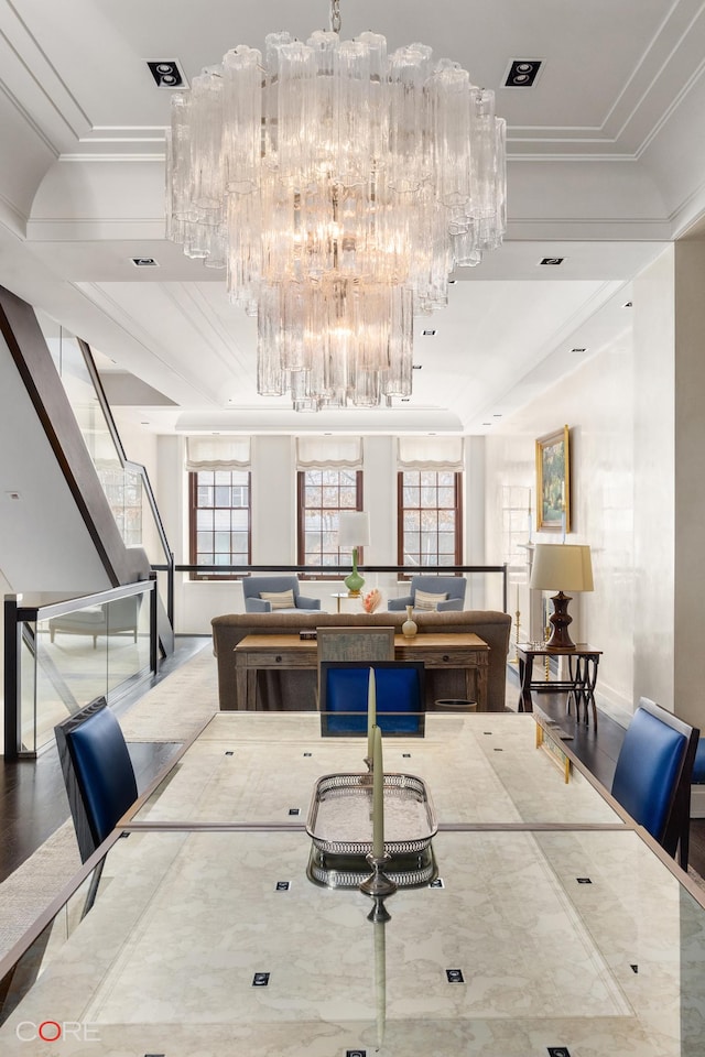 dining area featuring plenty of natural light, a chandelier, crown molding, and wood finished floors