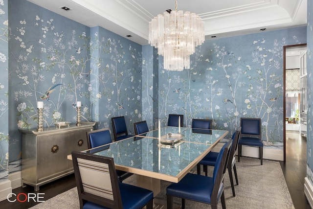 dining space with a notable chandelier, wood finished floors, ornamental molding, a tray ceiling, and wallpapered walls