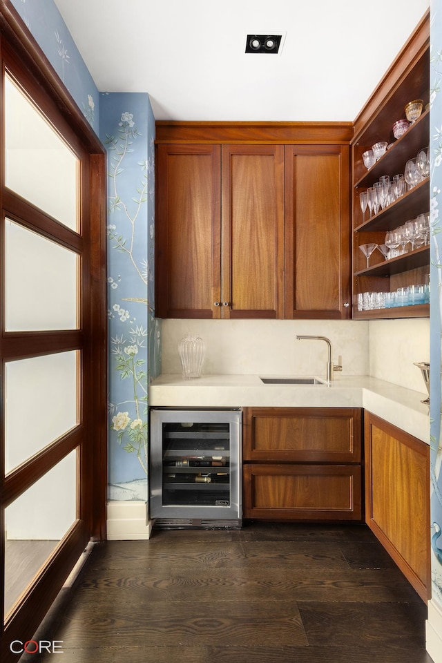 bar featuring dark wood finished floors, beverage cooler, a sink, and wallpapered walls