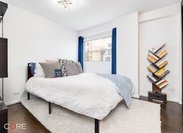 bedroom featuring dark wood-style floors and baseboards