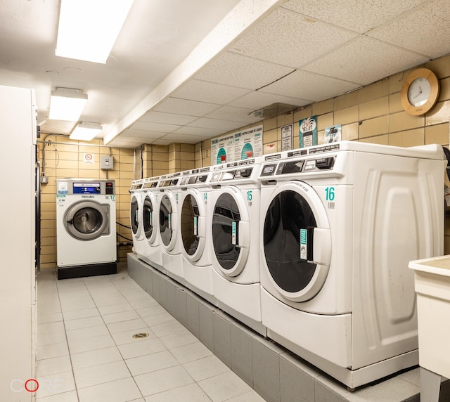 community laundry room with light tile patterned floors and washing machine and dryer