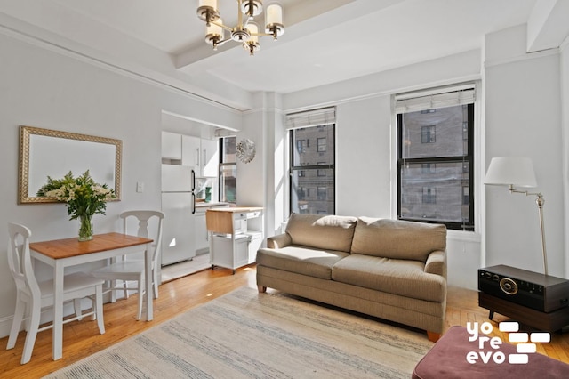 living room featuring a notable chandelier, beamed ceiling, and light wood-style floors