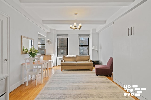 living area featuring light wood-type flooring, baseboards, a chandelier, and beam ceiling