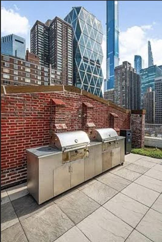 view of patio / terrace featuring a city view, exterior kitchen, and area for grilling