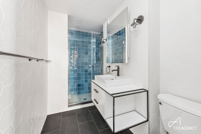 full bath featuring vanity, a stall shower, tile walls, toilet, and tile patterned floors