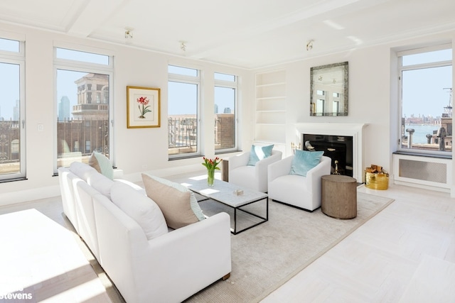 living area with built in shelves, a glass covered fireplace, and a city view