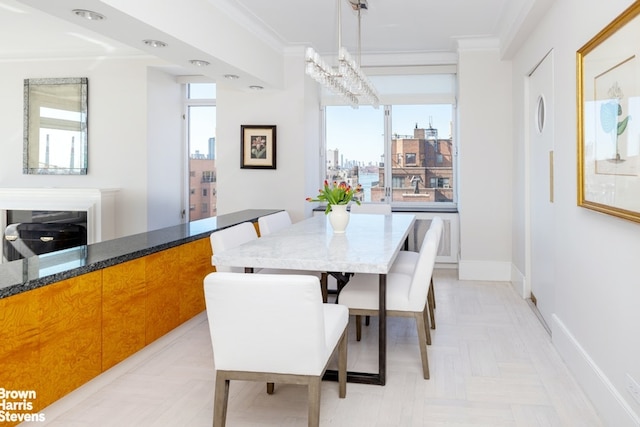 dining room featuring ornamental molding, a notable chandelier, and baseboards