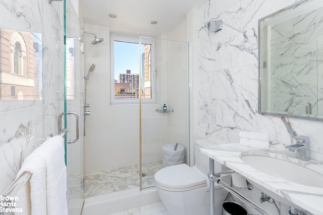 full bath with marble finish floor, a marble finish shower, toilet, vanity, and stone wall