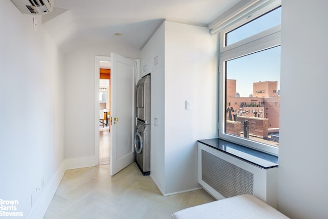 corridor featuring baseboards, radiator heating unit, a wall mounted AC, and stacked washer / drying machine