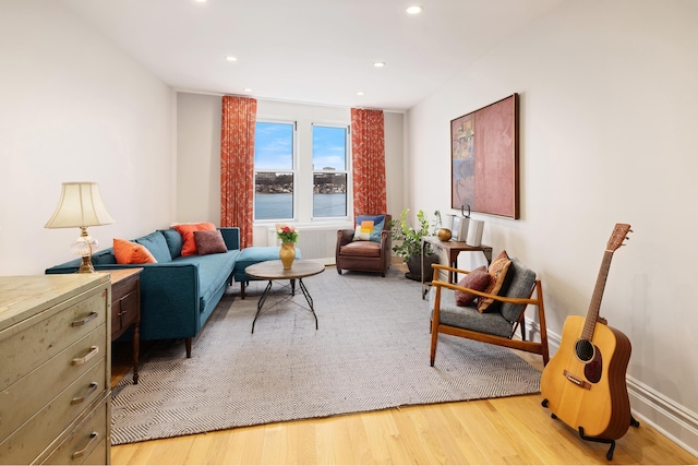 living area featuring baseboards, recessed lighting, and light wood-style floors