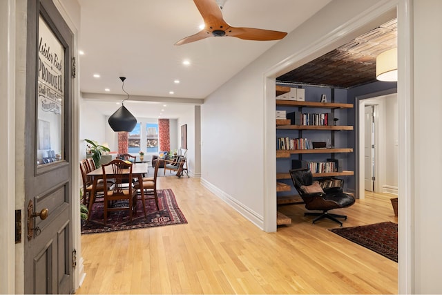 interior space with a ceiling fan, recessed lighting, light wood-style flooring, and baseboards