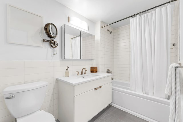 full bath with shower / tub combo with curtain, tile walls, toilet, and vanity