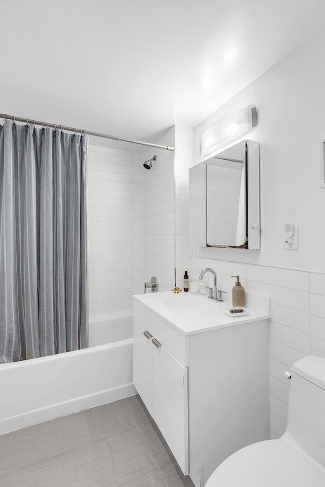 full bathroom featuring toilet, shower / tub combo, vanity, tile walls, and tile patterned floors