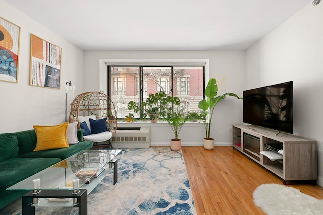 living room with radiator, baseboards, and wood finished floors