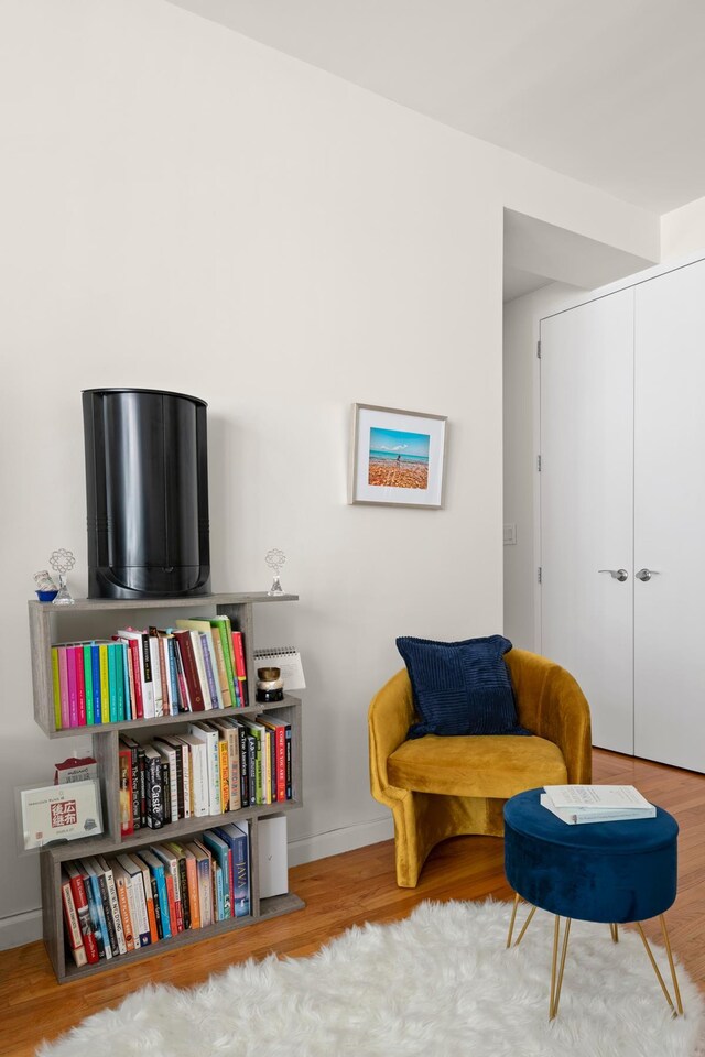 sitting room with baseboards and wood finished floors