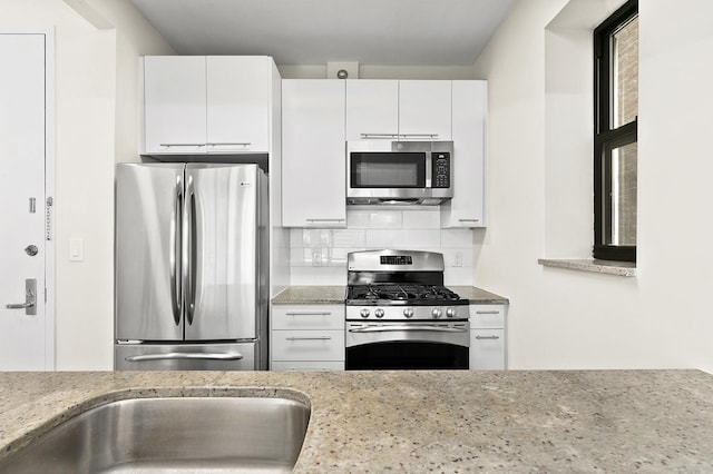 5 W 127th St Unit 2-A, New York City, NY 10027 - kitchen featuring stainless steel appliances, white cabinetry, tasteful backsplash, and light stone countertops