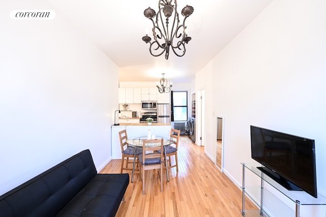 dining room with light wood-type flooring, visible vents, a chandelier, and baseboards