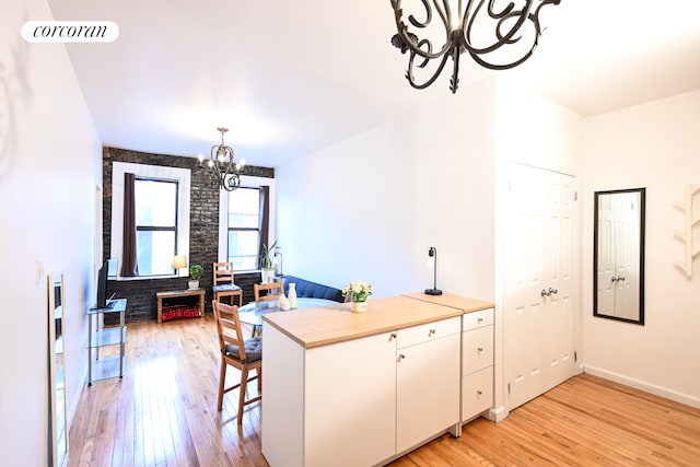 kitchen featuring an inviting chandelier, light wood-type flooring, visible vents, and white cabinets