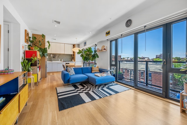 living room with a city view, visible vents, and light wood-type flooring