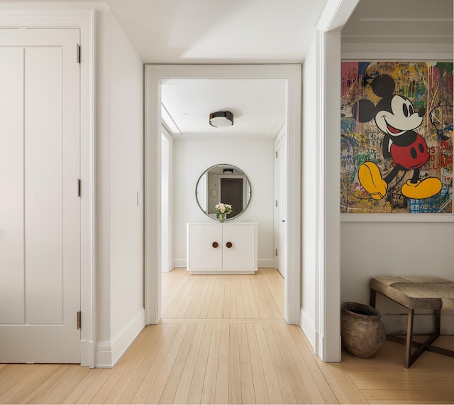 hall featuring wood-type flooring and baseboards