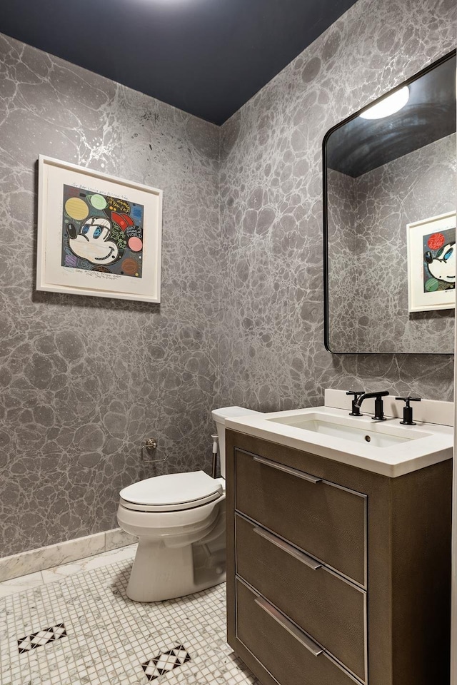 half bathroom with tile patterned flooring, vanity, and toilet