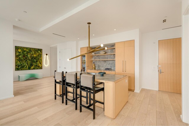30 Front St Unit 21A/D, New York City, NY 11201 - kitchen with a breakfast bar area, open shelves, light wood-style floors, a center island, and modern cabinets