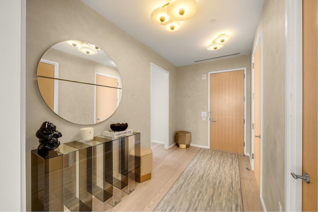 foyer entrance with baseboards and light wood-style floors