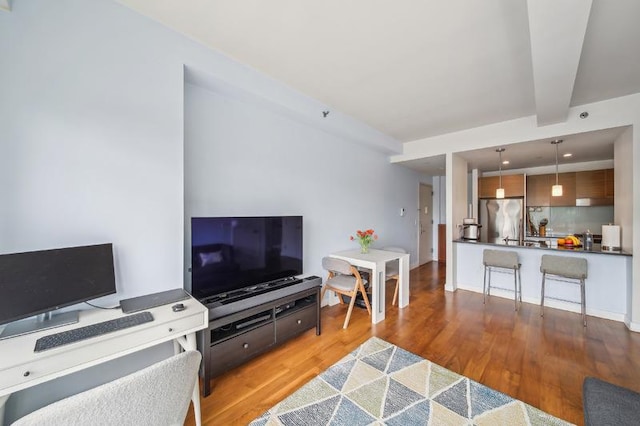 living area featuring wood finished floors and beam ceiling