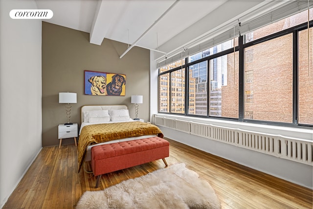 bedroom featuring beam ceiling, visible vents, and hardwood / wood-style flooring