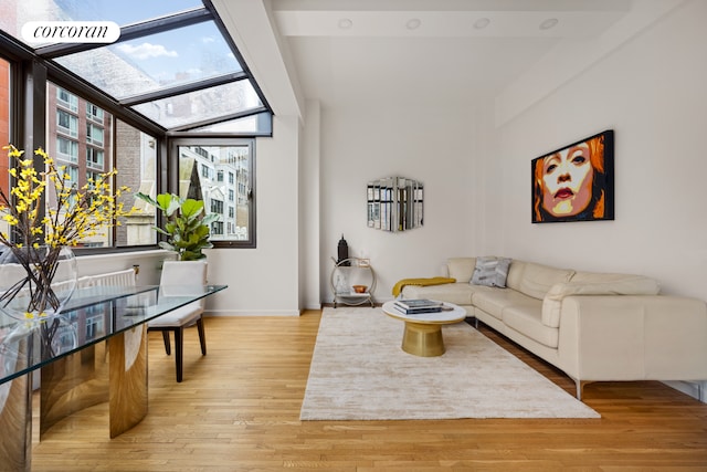 living area featuring a sunroom, light wood-style flooring, and baseboards