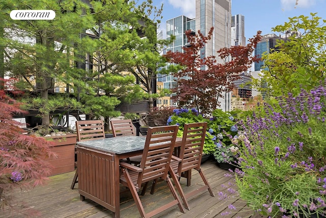 deck featuring outdoor dining area and a city view