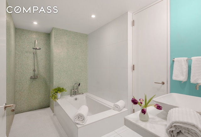 bathroom featuring tiled shower, a sink, tile patterned flooring, a garden tub, and tile walls