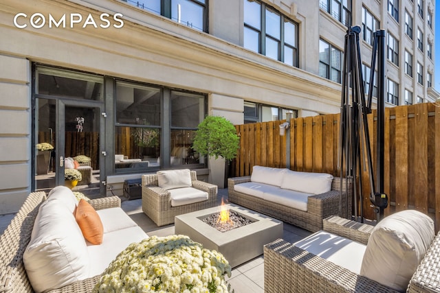 view of patio featuring an outdoor living space with a fire pit and fence