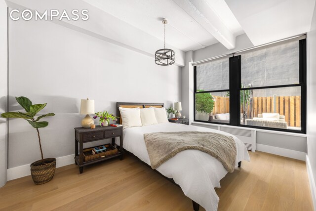 70 Washington St Unit 2K, New York City, NY 11201 - bedroom with radiator, baseboards, beamed ceiling, and light wood-style flooring