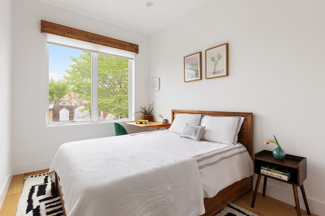 bedroom with baseboards and wood finished floors