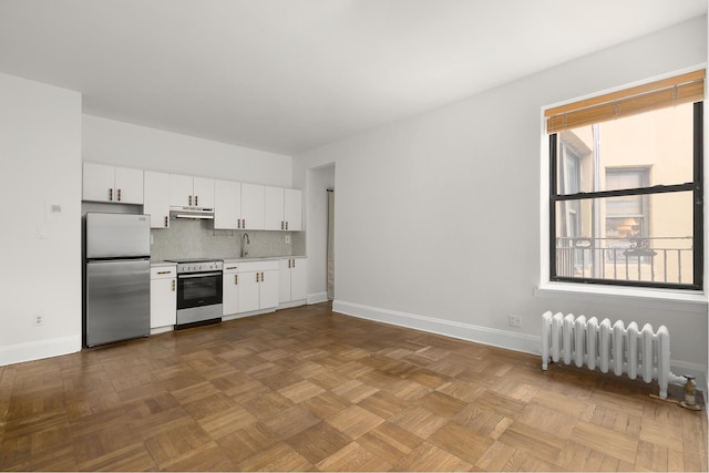 kitchen featuring plenty of natural light, appliances with stainless steel finishes, radiator, and a sink