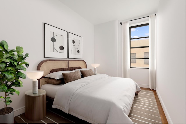 bedroom with baseboards and wood finished floors