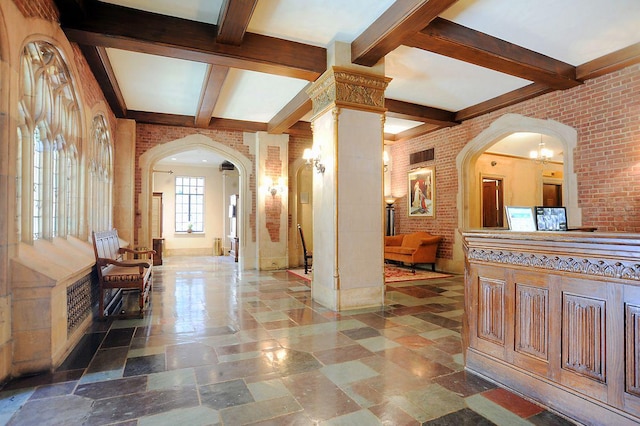 interior space featuring arched walkways, ornate columns, coffered ceiling, and brick wall