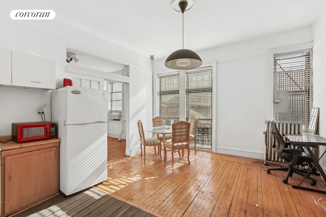 kitchen featuring visible vents, decorative light fixtures, light countertops, light wood-style flooring, and freestanding refrigerator