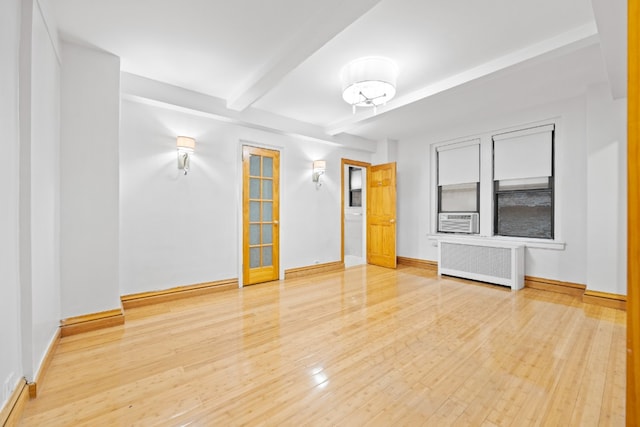 empty room with baseboards, radiator heating unit, beamed ceiling, wood finished floors, and cooling unit