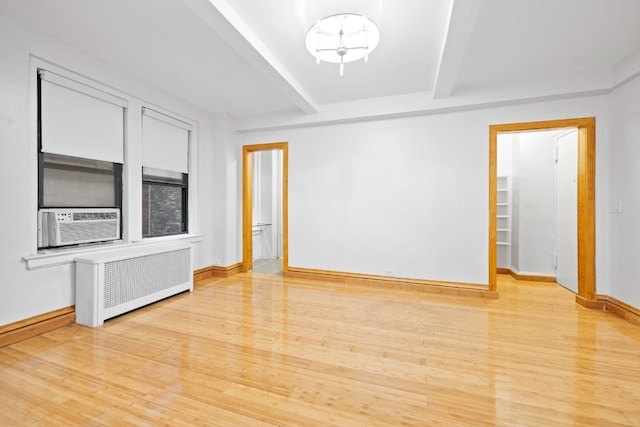 321 E 54th St Unit 2J, New York City, NY 10022 - unfurnished room featuring beamed ceiling, radiator, cooling unit, light wood finished floors, and baseboards