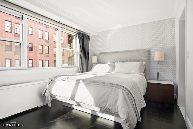 bedroom featuring crown molding, baseboards, wood finished floors, and wallpapered walls