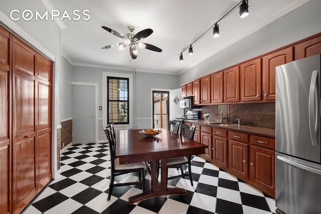 kitchen featuring dark countertops, light floors, appliances with stainless steel finishes, and ornamental molding