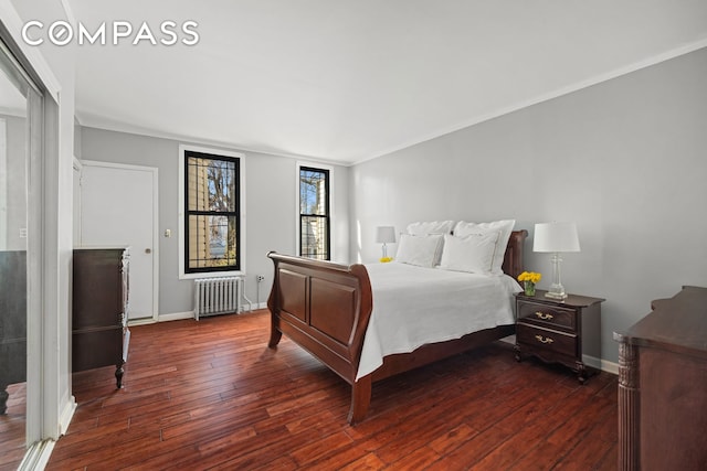 bedroom featuring baseboards, dark wood-style flooring, radiator heating unit, and ornamental molding