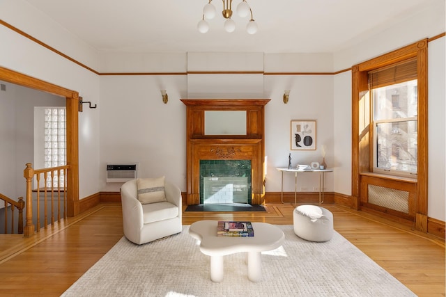 living room with plenty of natural light, baseboards, wood finished floors, and a glass covered fireplace