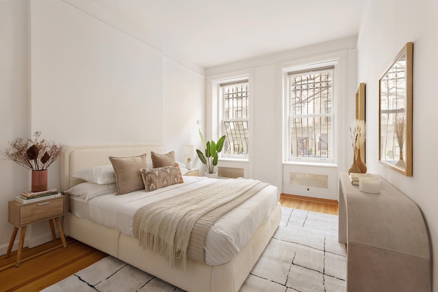 bedroom featuring baseboards and light wood finished floors