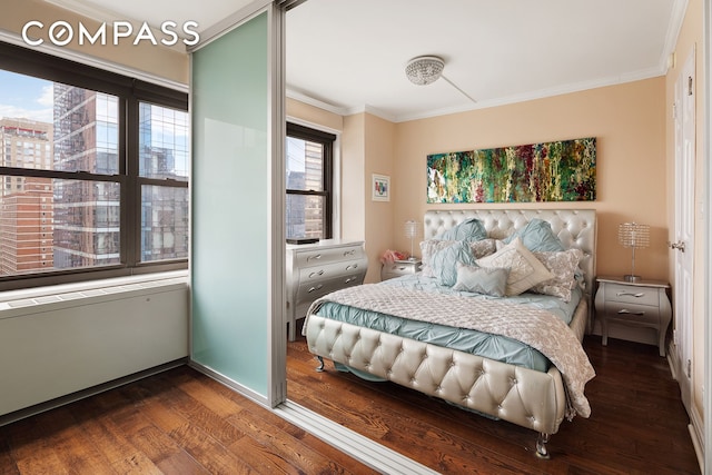 bedroom with baseboards, dark wood-style flooring, and crown molding